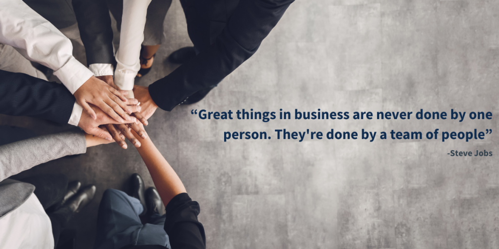 Photo of a team collaborating together and showing strength and cohesion, showingcasing one of the most appealing inspirational quotes for work team motivation: “Great things in business are never done by one person. They’re done by a team of people” from Steve Jobs.