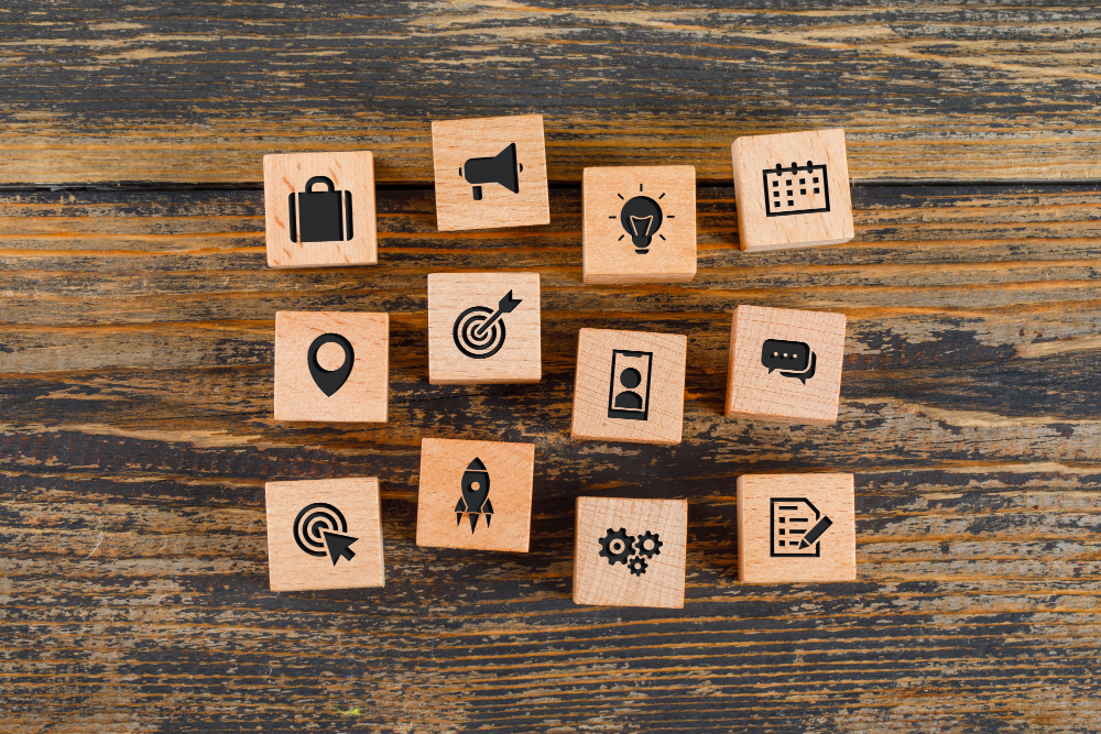 Wooden blocks with business-related icons, representing concepts like technology, communication, analytics, innovation, and strategy, illustrating employee onboarding trends 2025.