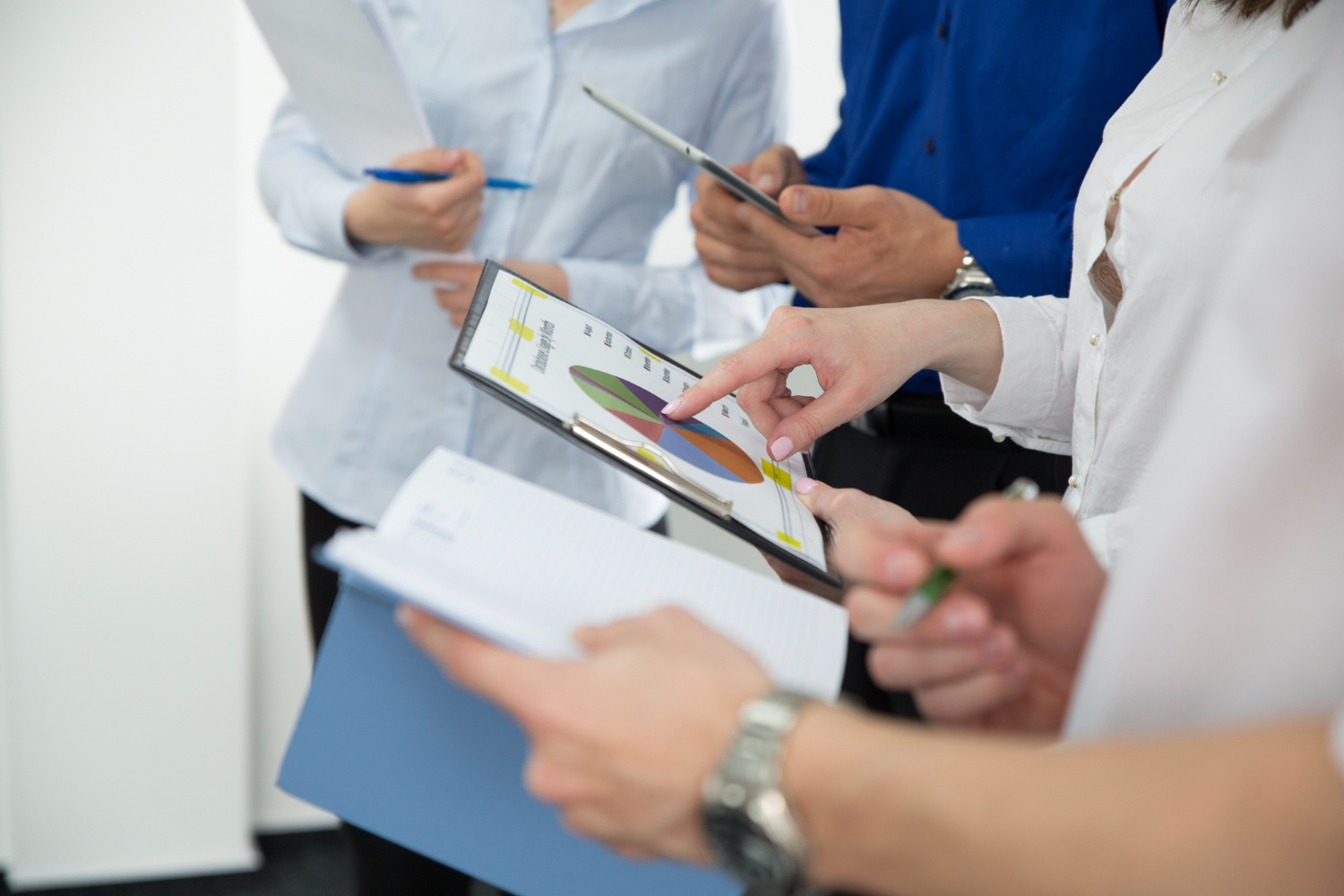 Close-up of a team reviewing charts and notes on a clipboard, likely discussing data collected from a training evaluation form.